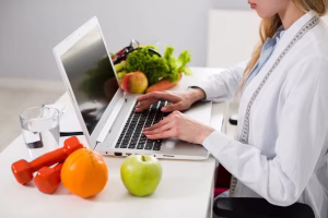 Dia del nutricionista imagen mujer en computadora y frutas