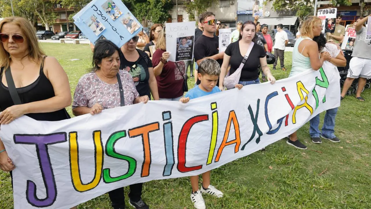 Familiares y vecinos de barrio San Martín sostienen pancartas con la cara del bebé Gian, exigiendo justicia y seguridad bajo el sol de la tarde en las puertas de los tribunales. foto: Juan José García. 