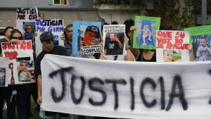 Familiares y vecinos de barrio San Martín sostienen pancartas con la cara del bebé Gian, exigiendo justicia y seguridad bajo el sol de la tarde en las puertas de los tribunales. foto: Juan José García.